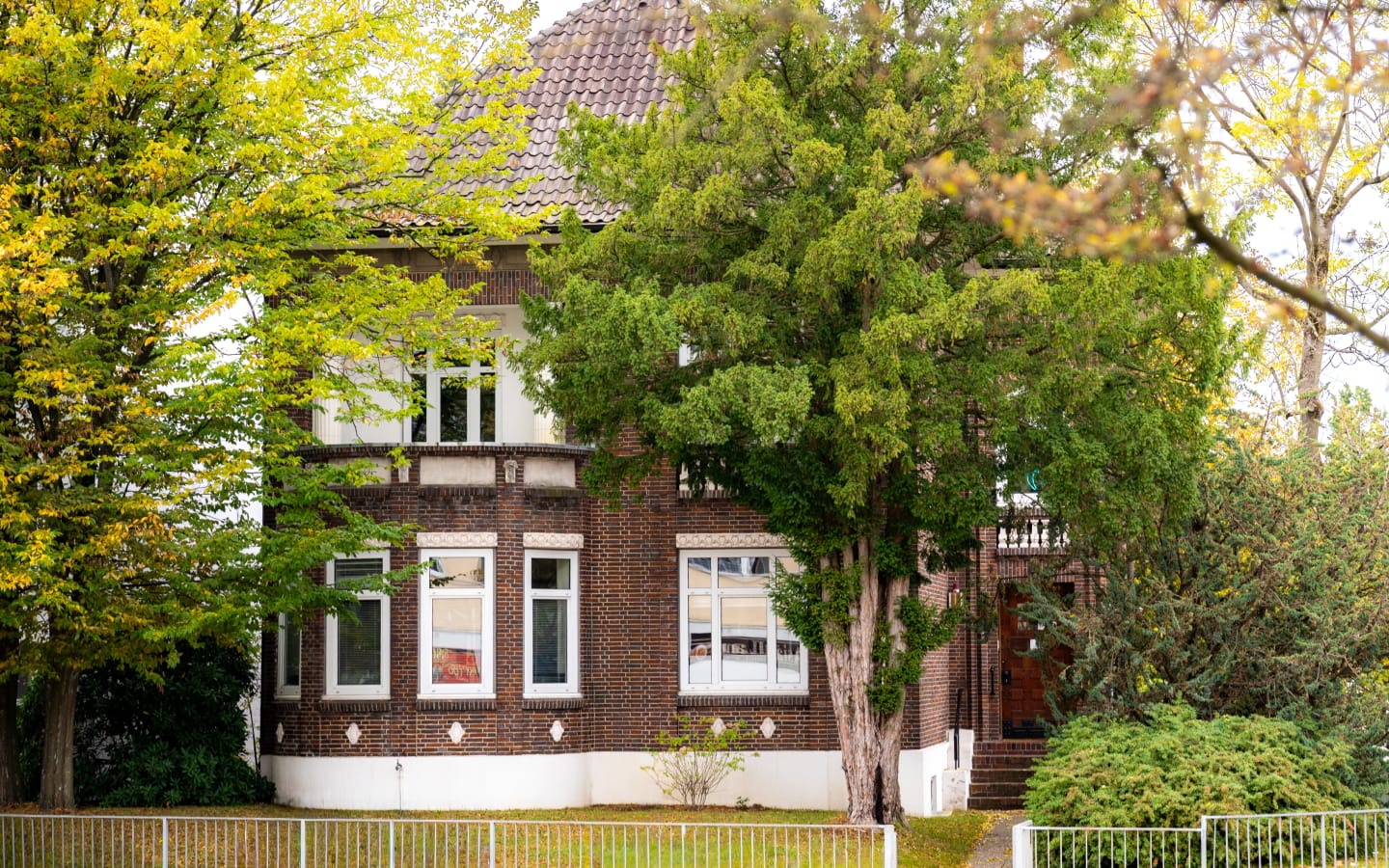 Die Rahlstedter Zahnärztevilla von außen mit viel Grün